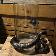 a glass with a snake in it sitting on a table