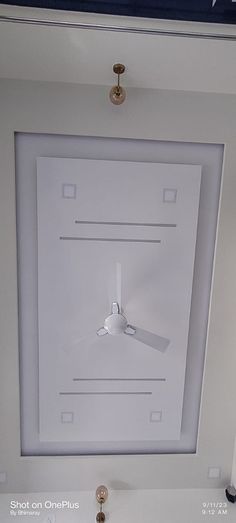 a ceiling fan mounted to the side of a white wall