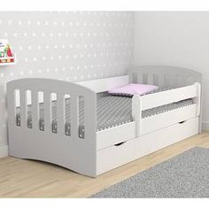 a child's bed with two drawers in the middle and a rug on the floor