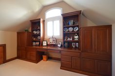 an empty room with built in bookshelves and cabinets