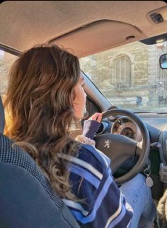 a woman sitting in the driver seat of a car