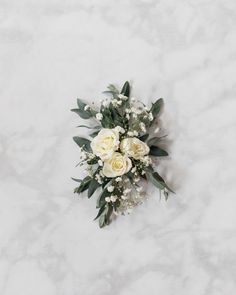 a bouquet of white roses and baby's breath on a marble surface