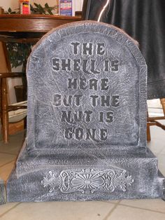 a tombstone with writing on it sitting in the middle of a room next to a table