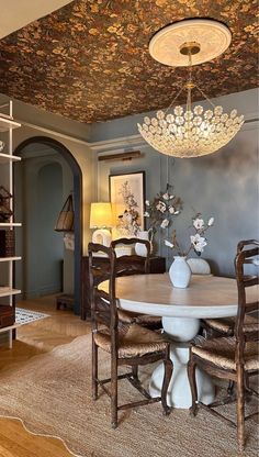 a dining room with a chandelier hanging from the ceiling