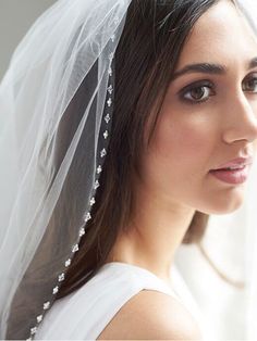 a woman wearing a veil with pearls on it