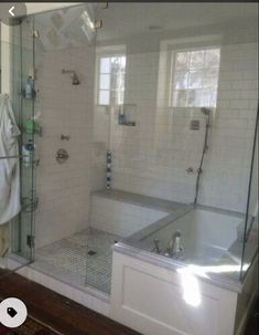 a bathroom with a walk in shower next to a bath tub