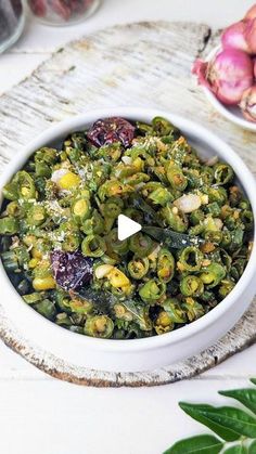 a white bowl filled with vegetables on top of a table