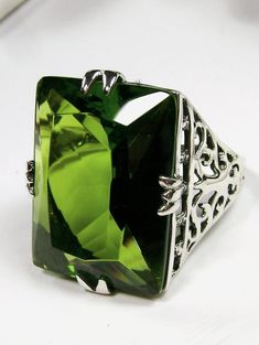 Simulated Green Peridot Ring  XR Design#9  Custom Made This is a brand new Vintage revival sterling silver filigree Huge 30ct Man-made/Simulated Green Peridot gemstone ring. The high-quality rectangle cut Green Peridot is 21mm in length by 16mm in width (5/8th inch by 11/16th inch). The inside of the band is marked 925 for sterling silver. Notice the beautiful swirl like the craftsmanship of the silver filigree setting. This ring is fun and very comfortable to wear. This is a lovely, very well m Sophisticated Art, Retro Jewelry, Peridot Ring, Peridot Gemstone, Sterling Silver Filigree, Green Peridot, Silver Art, Engraved Items, Art Deco Ring