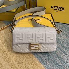 Iconic medium Baguette bag made of white soft nappa leather with a three-dimensional texture FF motif. Decorated with an FF clasp.Featuring a front flap, magnetic clasp, lined internal compartment with zip pocket and gold-finish metalware.The bag can be carried by hand, or either on the shoulder or cross-body thanks to the handle and shoulder strap, both detachable. Fendi Art, Art Purse, Fendi Baguette Bag, Baguette Recipe, Shopping Luxury, Luxury Love, Ootd Instagram, Fendi Fashion, Fendi Bag