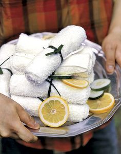 a person holding a plate full of towels and sliced lemons