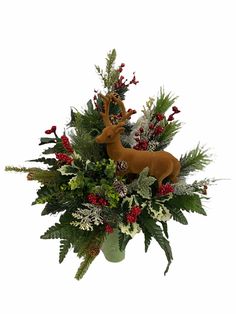 a vase filled with greenery and a deer figurine