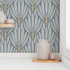 a white vase sitting on top of a counter next to a wallpapered wall