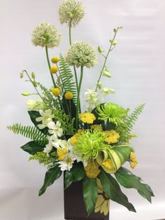 a vase filled with lots of green and white flowers