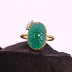 This Natural Carved Emerald Diamond Ring is a true treasure that combines the timeless elegance of emerald with the brilliance of diamonds. Crafted with utmost precision, this ring features a stunning emerald gemstone that has been intricately carved to enhance its natural beauty. The emerald's deep green hue adds a touch of sophistication and symbolism, making it not only visually captivating but also the perfect gift for someone born in May, as emerald is the birthstone for this month.  This R Oval Emerald Ring With Single Cut Diamonds, Green Oval Diamond Ring With Single Cut, Green Oval Single Cut Diamond Rings, Emerald Rings With Single Cut Diamonds For Gifts, Heirloom Oval Emerald Ring With Single Cut Diamonds, Emerald Ring With Single Cut Diamonds As Gift, Exquisite Hallmarked Emerald Ring, Luxury Round Emerald Ring With Stone Setting, Luxury Oval Emerald Ring With Stone Setting