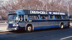 a blue bus is parked on the side of the road