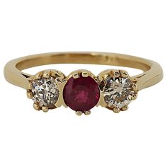 A tailored three stone ring featuring a center ruby weighing approximately 0.35 carat illuminated by two European cut diamonds weighing approximately 0.40 carat total mounted in 14 karat yellow gold. Current size 6.75. Three Stone Ring, European Cut Diamonds, Three Stone Rings, Vintage Diamond, Three Stone, Stone Ring, Cocktail Rings, Gold Bands, Stone Rings