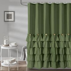 a green shower curtain with ruffles on the bottom and gold buttons at the bottom