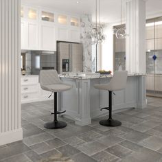 two stools sit in front of a kitchen island with marble countertops and white cabinets