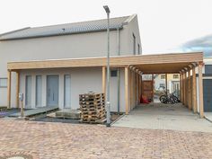 a house with a large wooden structure in front of it and bikes parked outside the building