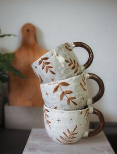 three coffee mugs stacked on top of each other