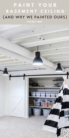 an unfinished basement with white walls and black and white striped teepeel on the floor