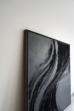 a black and white abstract painting hanging on the wall