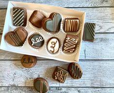 chocolates are arranged in the shape of hearts on a white platter with monogrammed letters