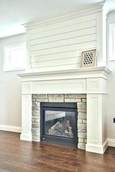 an empty living room with a fireplace and wood floors