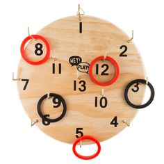 a wooden clock with red and black rings on it