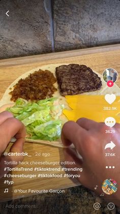 someone is making hamburgers on a cutting board with cheese, lettuce and other ingredients