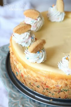 a cake with white frosting and cookies on top is sitting on a blue plate