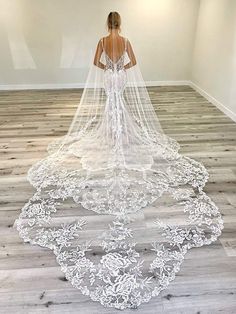 a woman in a wedding dress is standing on the floor with her back to the camera