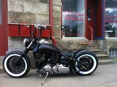 a black motorcycle parked in front of a building