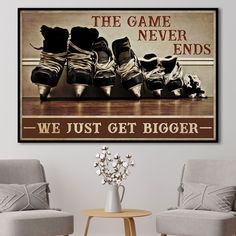 two chairs and a table in front of a wall with a poster on it that says, the game never ends we just get bigger