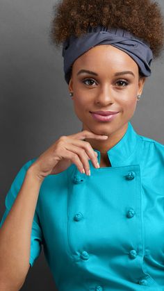 a woman with an afro in a blue shirt and headband posing for the camera