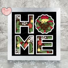 the word home is made out of paper and decorated with christmas decorations, including holly wreaths