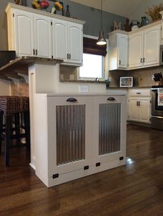 a kitchen with white cabinets and wood floors