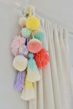 multicolored pom - poms hanging on the curtain