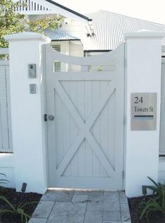 a white gate with a sign on it