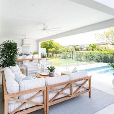 a living room filled with furniture next to a swimming pool