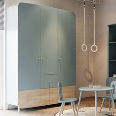 a room with two chairs, a table and some cupboards on the wall next to each other