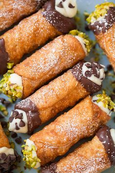 several desserts are arranged on a plate with sprinkles and powdered sugar