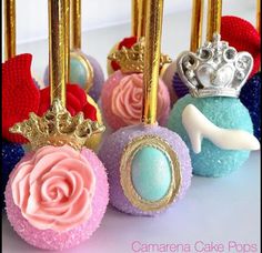 there are some cake pops decorated like princess crowns on top of each other with pink and blue frosting