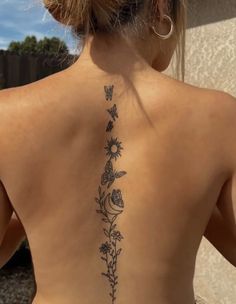 a woman's back tattoo with flowers and butterflies