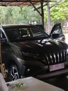 a man standing next to a car in a garage