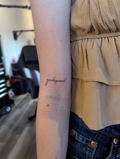 a woman with a tattoo on her arm that says, happiness in cursive writing