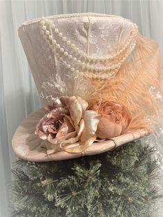 "This elegant Victorian Christmas tree topper top hat is READY TO SHIP. Use the top hat as a tree topper for the holiday season and or a decoration centerpiece for anywhere in your home throughout the year. The tree topper top hat is made as follows: *The top hat taper/body is made with ivory lace fabric. * The brim is made with mauve fabric. *The band is made with mauve lace. Decorated with: *Feather, flowers, string of pearls, lace. *10\" wide lace bow with tails at the back. * Measurements ar Victorian Christmas Centerpieces, Fancy Top Hat, Elegant Christmas Tree Toppers, Victorian Tree Topper, Vintage Top Hat For Wedding And Kentucky Derby, Vintage Top Hat With High Crown For Wedding, Vintage High Crown Top Hat For Wedding, Vintage White Top Hat For Wedding, Victorian Mini Hats With Curved Brim For Wedding