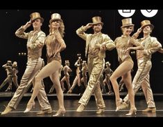 the dancers are all dressed in gold and white outfits, with hats on their heads