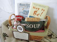 a basket filled with books and snacks sitting on top of a bed next to a pillow