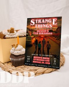 a cupcake with a candle on it next to a book about strange things in the past